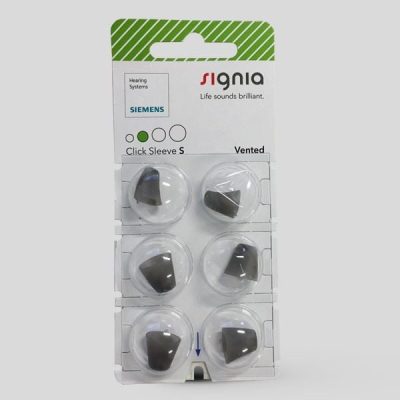 A package of Signia Click Sleeve (Vented) contains six small, dark gray silicone hearing aid tips in clear blister packs on a white and green backing card.